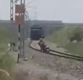 Young motorcyclist in Gujarat miraculously escapes being crushed by train as stunt goes wrong
