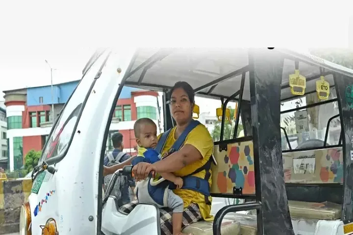 Single mother drives e-rickshaw with her son strapped around her in Noida
